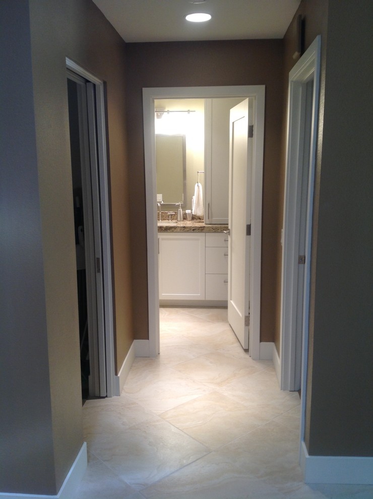 Example of a large transitional master beige floor bathroom design with shaker cabinets, white cabinets, white walls and an undermount sink