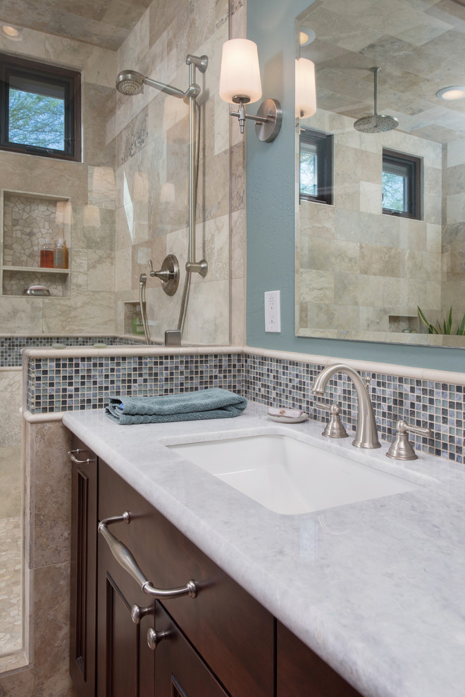 Example of a large transitional master gray tile and stone tile ceramic tile walk-in shower design in Phoenix with an undermount sink, raised-panel cabinets, dark wood cabinets, granite countertops and blue walls