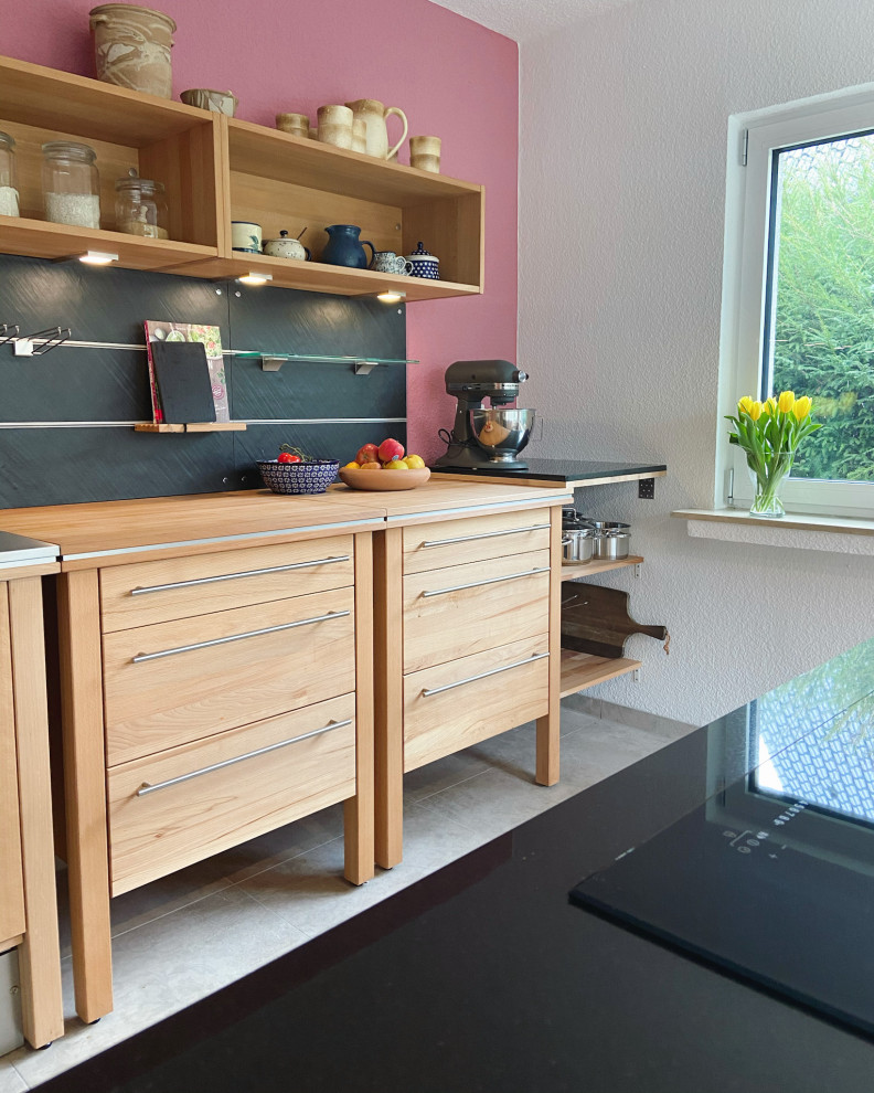 Photo of a mid-sized contemporary galley open plan kitchen in Dusseldorf with light wood cabinets and with island.