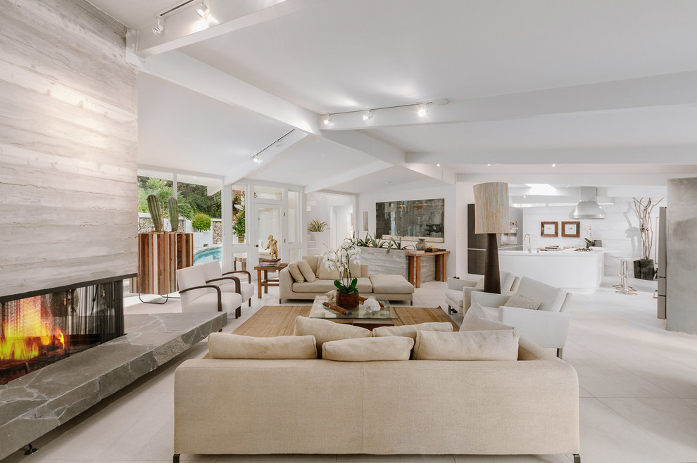 Inspiration for an expansive midcentury formal open concept living room in Los Angeles with white walls, a two-sided fireplace, a concrete fireplace surround, no tv and white floor.
