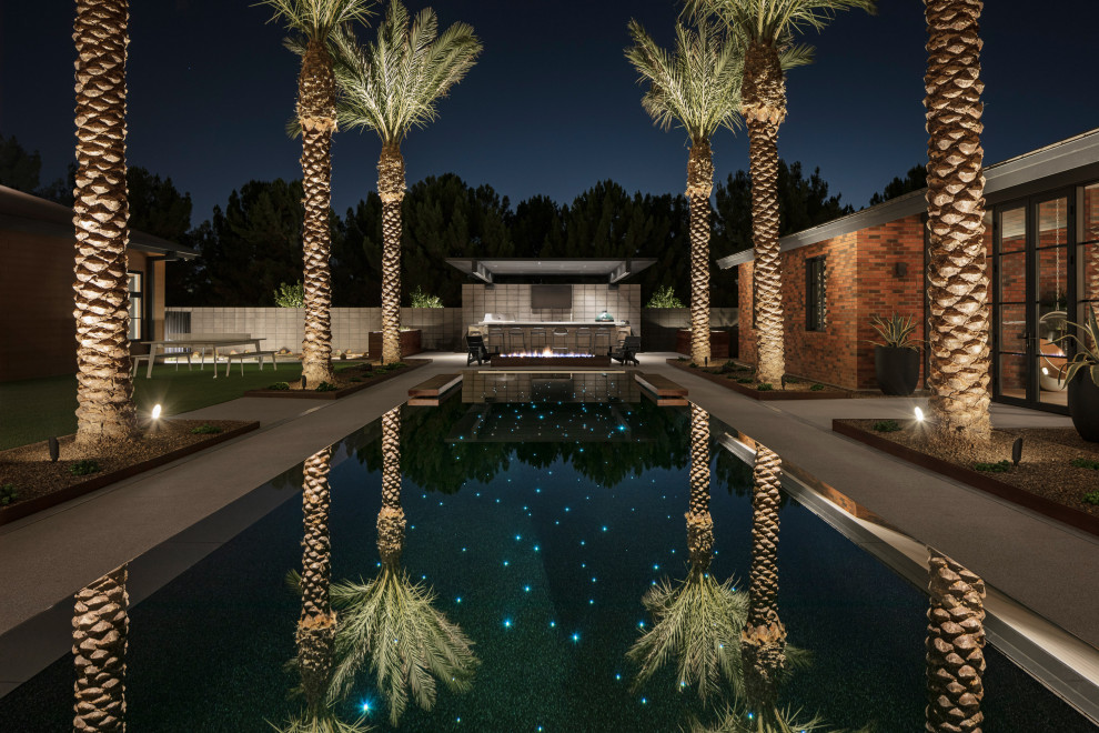 На фото: большой прямоугольный бассейн на внутреннем дворе в современном стиле с покрытием из бетонных плит