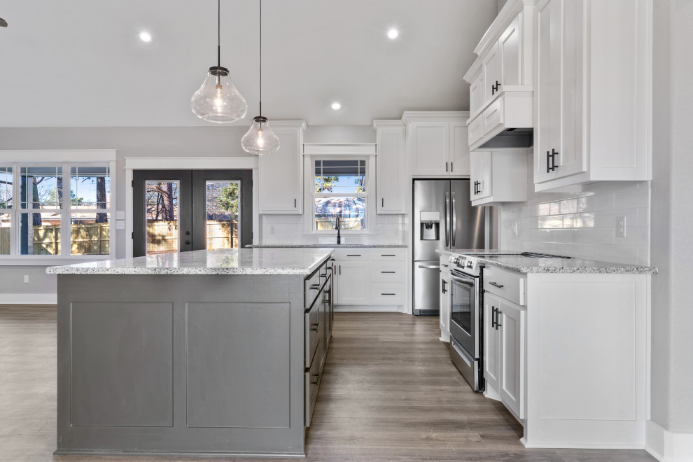 Design ideas for a country l-shaped kitchen in Dallas with shaker cabinets, white cabinets, granite benchtops, ceramic splashback, stainless steel appliances and with island.