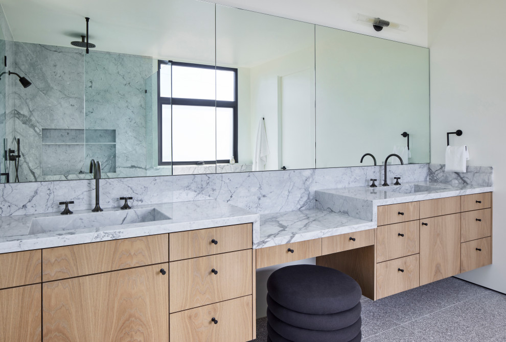 Large modern master bathroom in Los Angeles with flat-panel cabinets, light wood cabinets, a freestanding tub, a corner shower, a one-piece toilet, black and white tile, stone slab, white walls, terrazzo floors, an undermount sink, marble benchtops, grey floor, a hinged shower door, white benchtops, a double vanity, a floating vanity and an enclosed toilet.