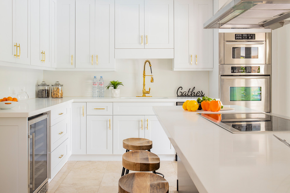 Inspiration for a mid-sized contemporary galley eat-in kitchen in Miami with an undermount sink, shaker cabinets, white cabinets, quartz benchtops, white splashback, marble splashback, stainless steel appliances, marble floors, with island, beige floor and white benchtop.
