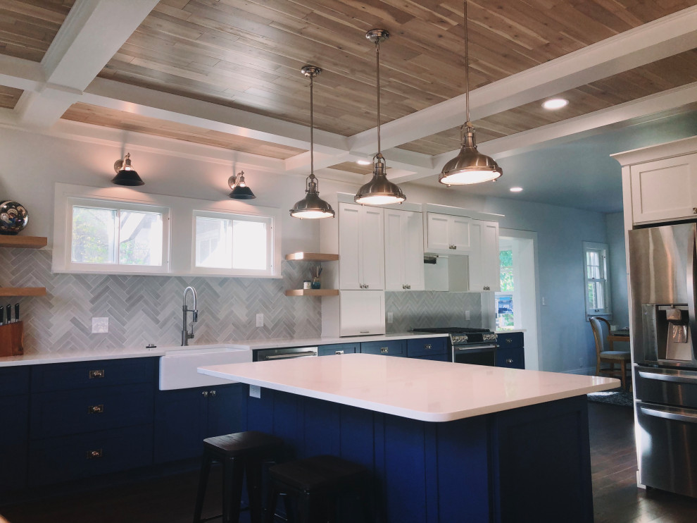 Photo of a large arts and crafts u-shaped eat-in kitchen in Indianapolis with a farmhouse sink, shaker cabinets, blue cabinets, quartzite benchtops, grey splashback, ceramic splashback, stainless steel appliances, dark hardwood floors, with island, brown floor, white benchtop and timber.