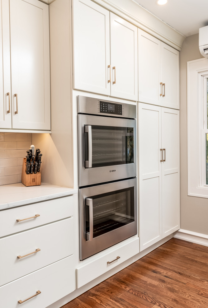 Inspiration for a transitional kitchen in Philadelphia with an undermount sink, shaker cabinets, quartz benchtops, white splashback, stainless steel appliances, medium hardwood floors and with island.