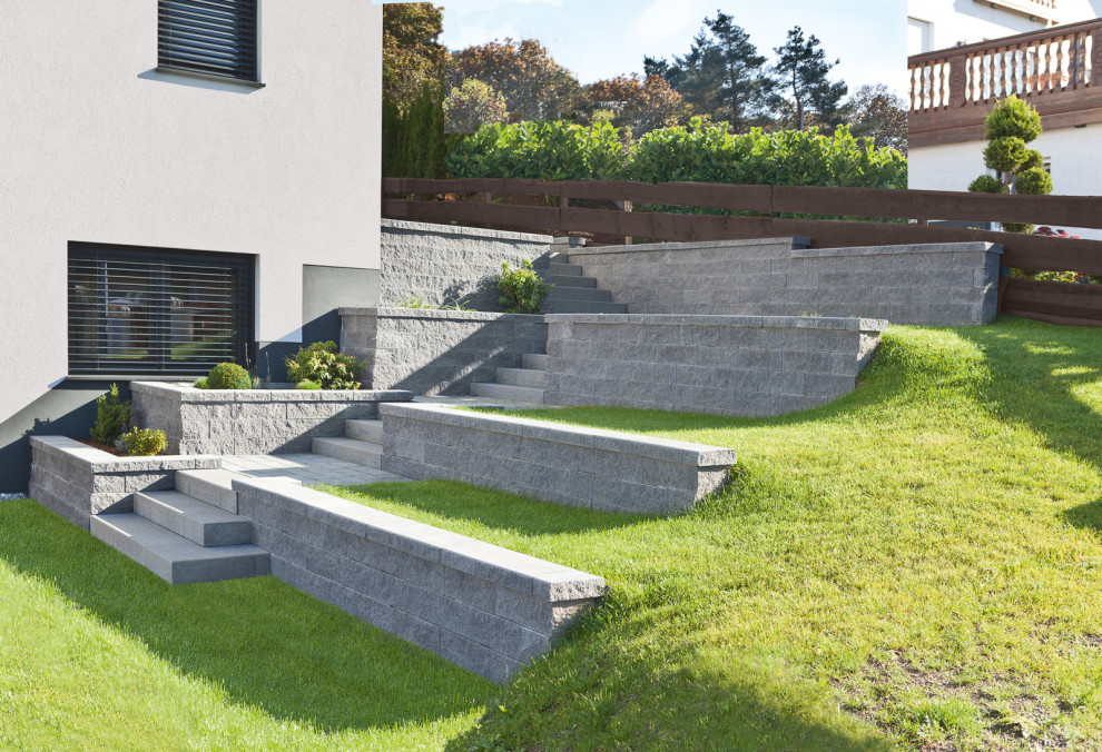 Idee per un giardino stile rurale con un muro di contenimento, un pendio, una collina o una riva e pavimentazioni in cemento