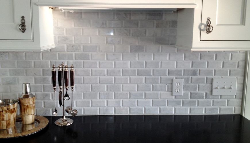 Example of a transitional kitchen design with recessed-panel cabinets, white cabinets, granite countertops, gray backsplash and porcelain backsplash