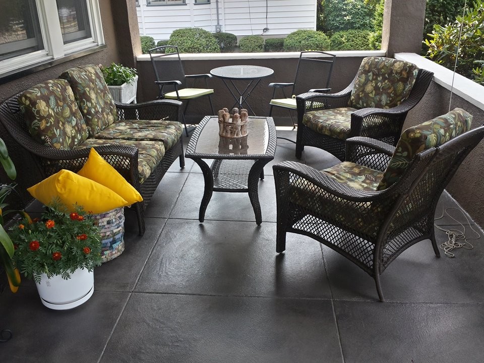 This is an example of a mid-sized front yard verandah in New York with concrete pavers and a roof extension.