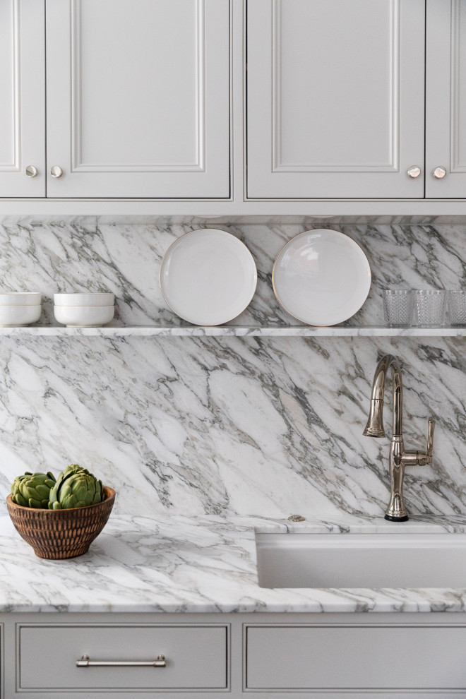 Inspiration for a small transitional l-shaped dark wood floor and brown floor enclosed kitchen remodel in Boston with an undermount sink, shaker cabinets, white cabinets, marble countertops, white backsplash, marble backsplash, paneled appliances, an island and white countertops