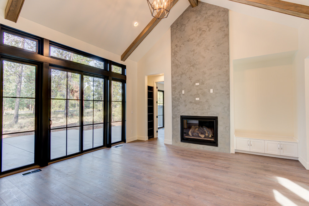This is an example of a mid-sized country formal open concept living room with white walls, light hardwood floors, a standard fireplace, a concrete fireplace surround, no tv and beige floor.