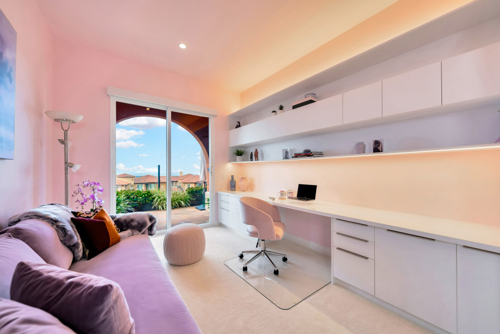 Inredning av ett modernt mellanstort arbetsrum, med rosa väggar, heltäckningsmatta, ett inbyggt skrivbord och vitt golv