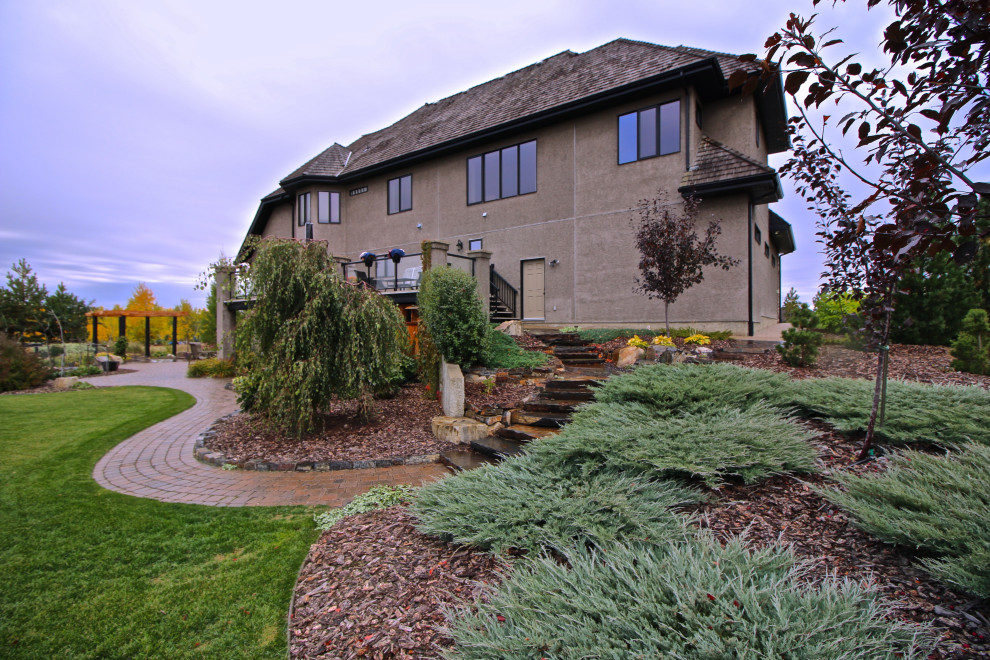 Design ideas for a huge rustic backyard landscaping in Edmonton.