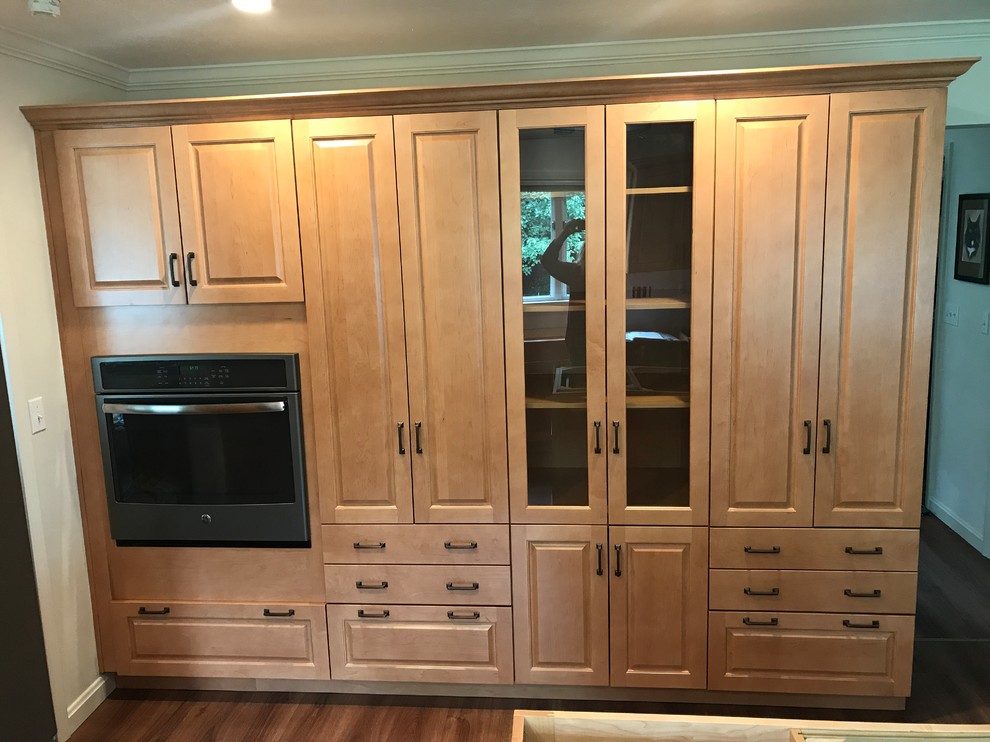 This is an example of a traditional kitchen in Other with raised-panel cabinets, orange cabinets, quartzite benchtops, vinyl floors, with island and brown floor.