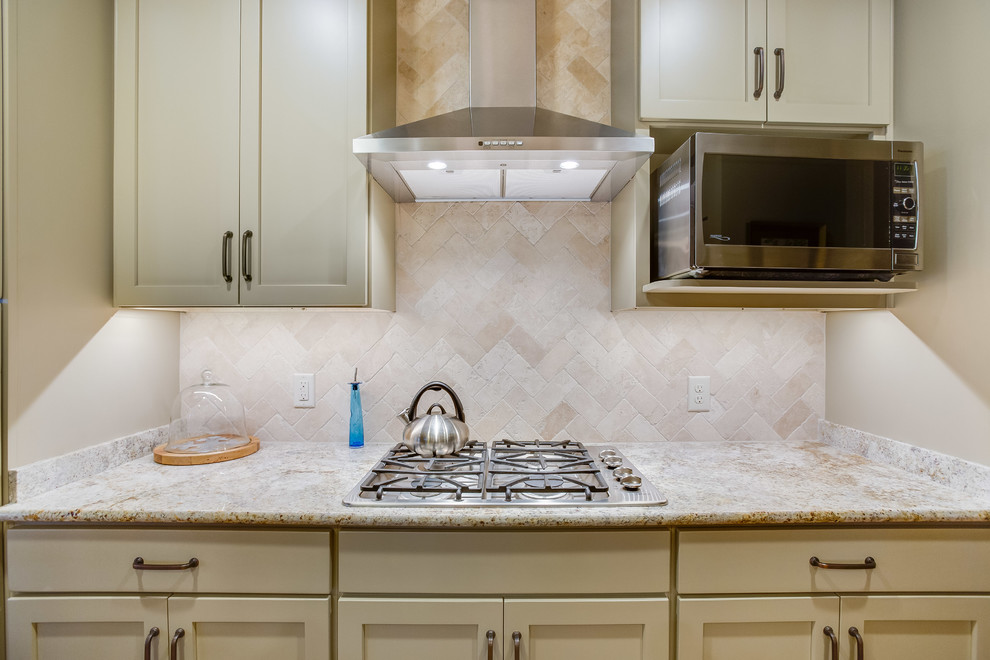 Enclosed kitchen - transitional u-shaped medium tone wood floor and brown floor enclosed kitchen idea in Birmingham with a double-bowl sink, shaker cabinets, beige cabinets, granite countertops, beige backsplash, travertine backsplash, stainless steel appliances and an island