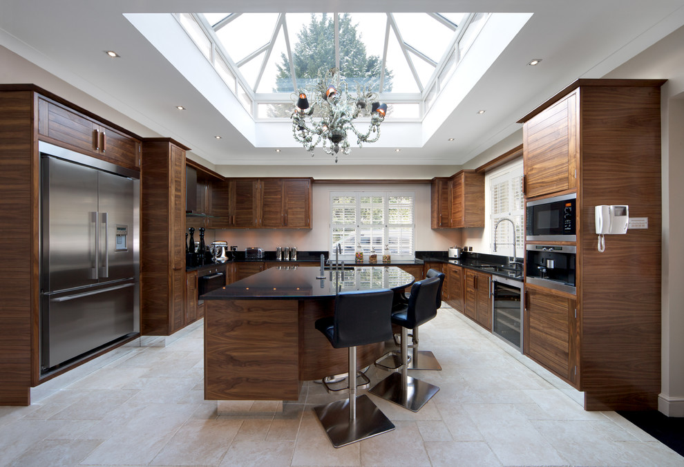 This is an example of a contemporary u-shaped kitchen in Other with dark wood cabinets, stainless steel appliances, with island and black benchtop.