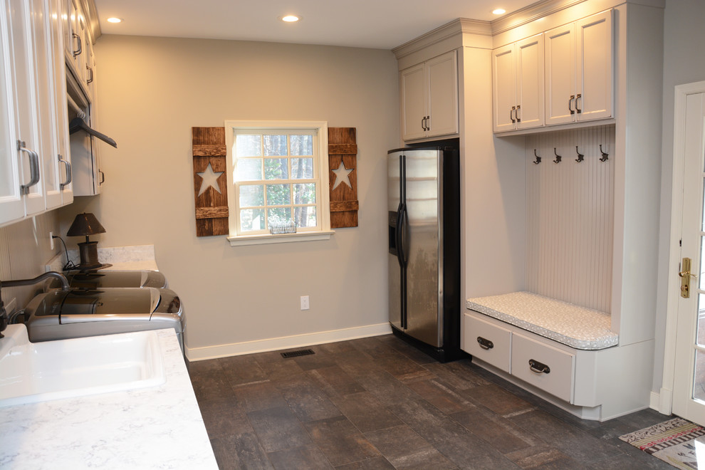 Inspiration for a large traditional galley utility room in Baltimore with a single-bowl sink, recessed-panel cabinets, grey cabinets, quartz benchtops, grey walls, a side-by-side washer and dryer, brown floor and white benchtop.