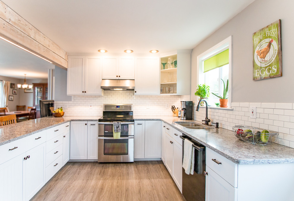 Small u-shaped open plan kitchen in Seattle with an undermount sink, shaker cabinets, white cabinets, granite benchtops, grey splashback, subway tile splashback, stainless steel appliances, vinyl floors and a peninsula.
