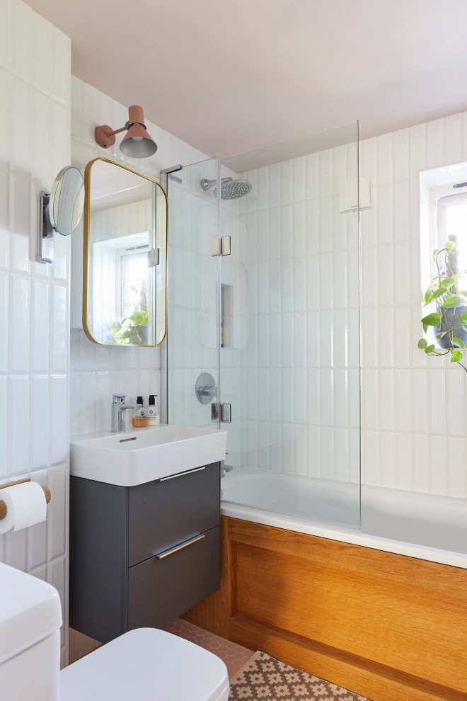 На фото: ванная комната в стиле фьюжн с плоскими фасадами, серыми фасадами, ванной в нише, душем над ванной, белой плиткой, душевой кабиной, консольной раковиной, оранжевым полом, открытым душем, нишей, тумбой под одну раковину и подвесной тумбой