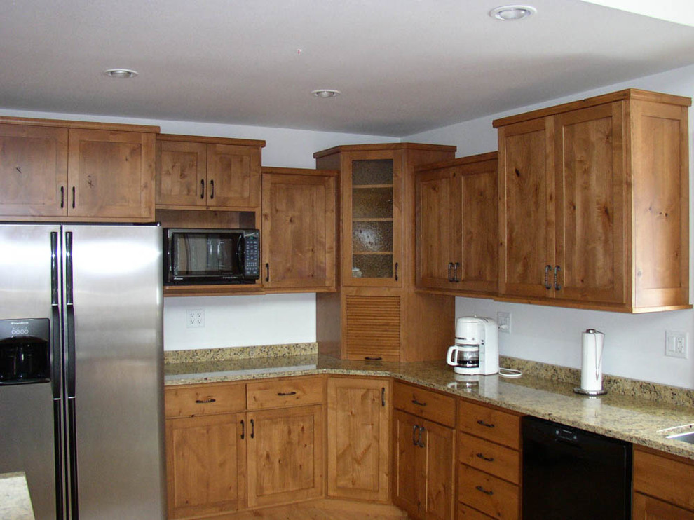 Open concept kitchen - large rustic l-shaped light wood floor and brown floor open concept kitchen idea with an undermount sink, shaker cabinets, medium tone wood cabinets, stainless steel appliances, an island and granite countertops