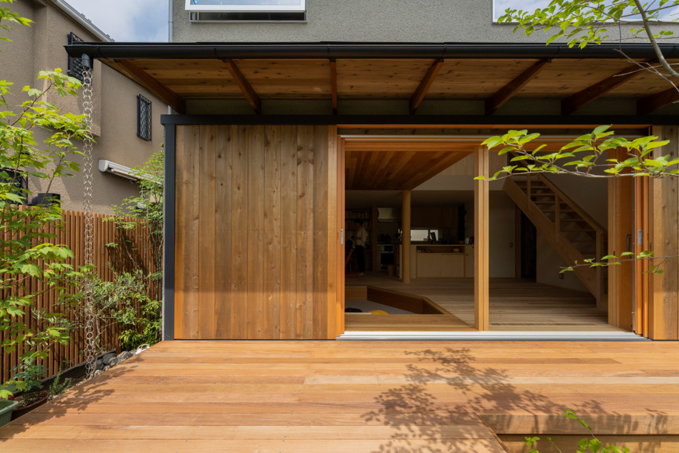 This is an example of a mid-sized porch design in Yokohama with decking and a roof extension.