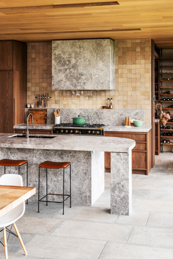 Huge trendy single-wall gray floor and shiplap ceiling open concept kitchen photo in Melbourne with a double-bowl sink, flat-panel cabinets, medium tone wood cabinets, limestone countertops, beige backsplash, ceramic backsplash, black appliances, an island and gray countertops