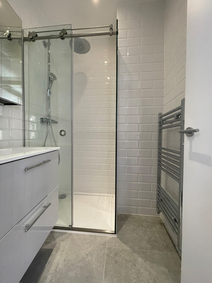 Design ideas for a small contemporary shower room bathroom in London with flat-panel cabinets, grey cabinets, a wall mounted toilet, white tiles, porcelain tiles, white walls, porcelain flooring, a built-in sink, grey floors, a sliding door, a single sink and a floating vanity unit.