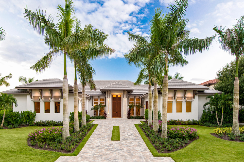 This is an example of a tropical one-storey white exterior in Miami with a hip roof.