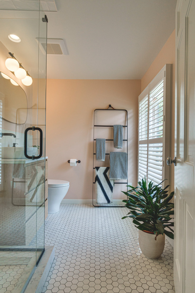 Example of a small minimalist white tile and ceramic tile ceramic tile, white floor and single-sink corner shower design in Other with flat-panel cabinets, light wood cabinets, a one-piece toilet, pink walls, a vessel sink, quartz countertops, a hinged shower door, multicolored countertops and a floating vanity