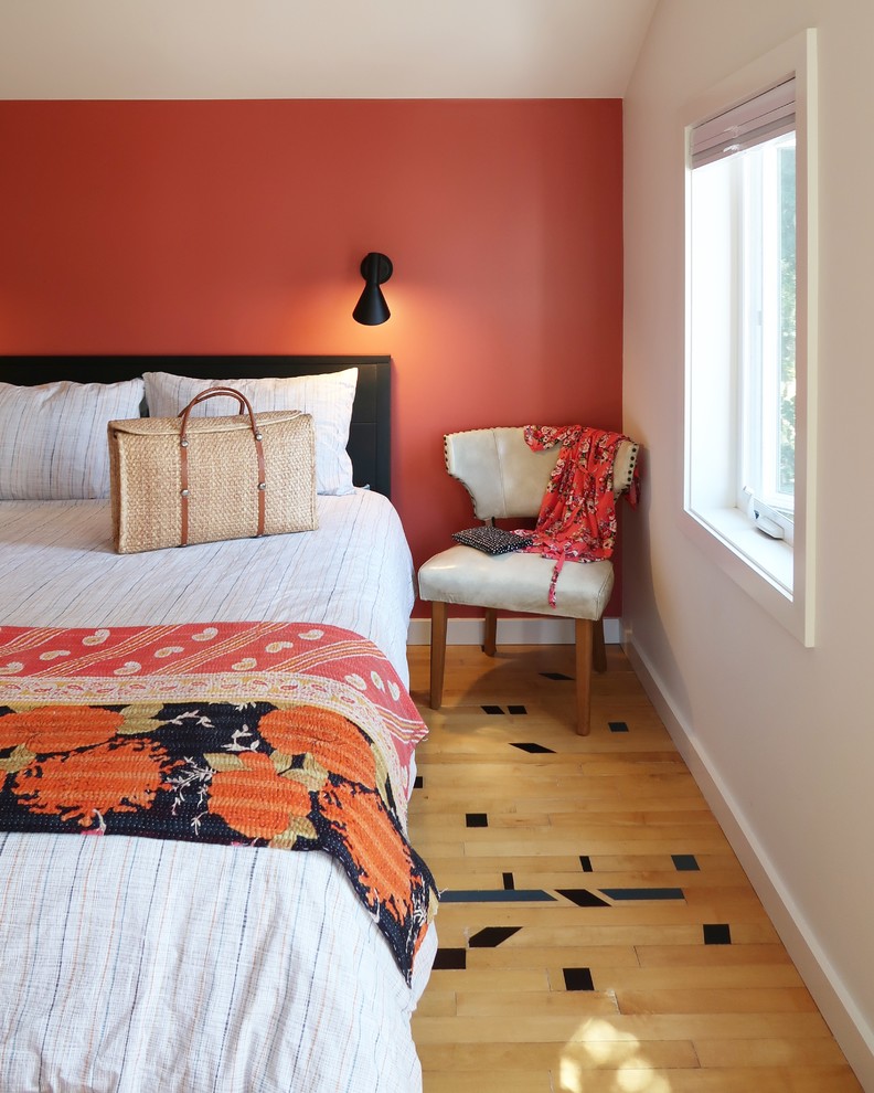 Small eclectic master bedroom in Portland with orange walls, light hardwood floors and beige floor.