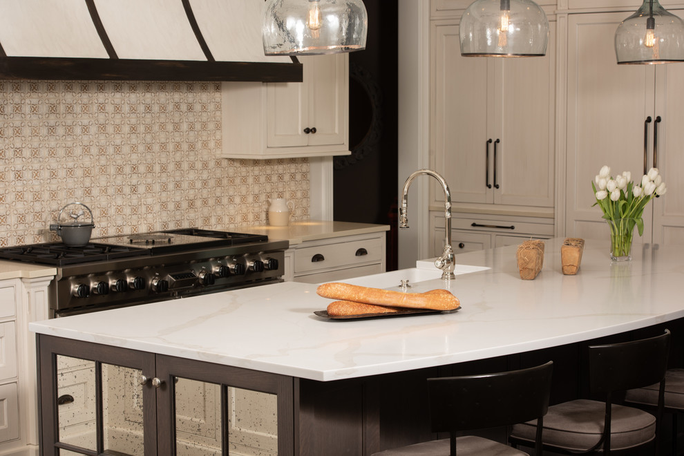 Example of a mid-sized classic u-shaped dark wood floor and brown floor open concept kitchen design in Chicago with a farmhouse sink, beaded inset cabinets, beige cabinets, quartzite countertops, beige backsplash, porcelain backsplash, paneled appliances, an island and white countertops