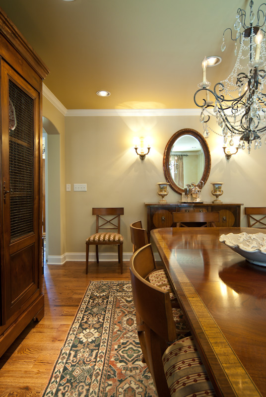 Example of a large mountain style medium tone wood floor kitchen/dining room combo design with beige walls, a standard fireplace and a stone fireplace
