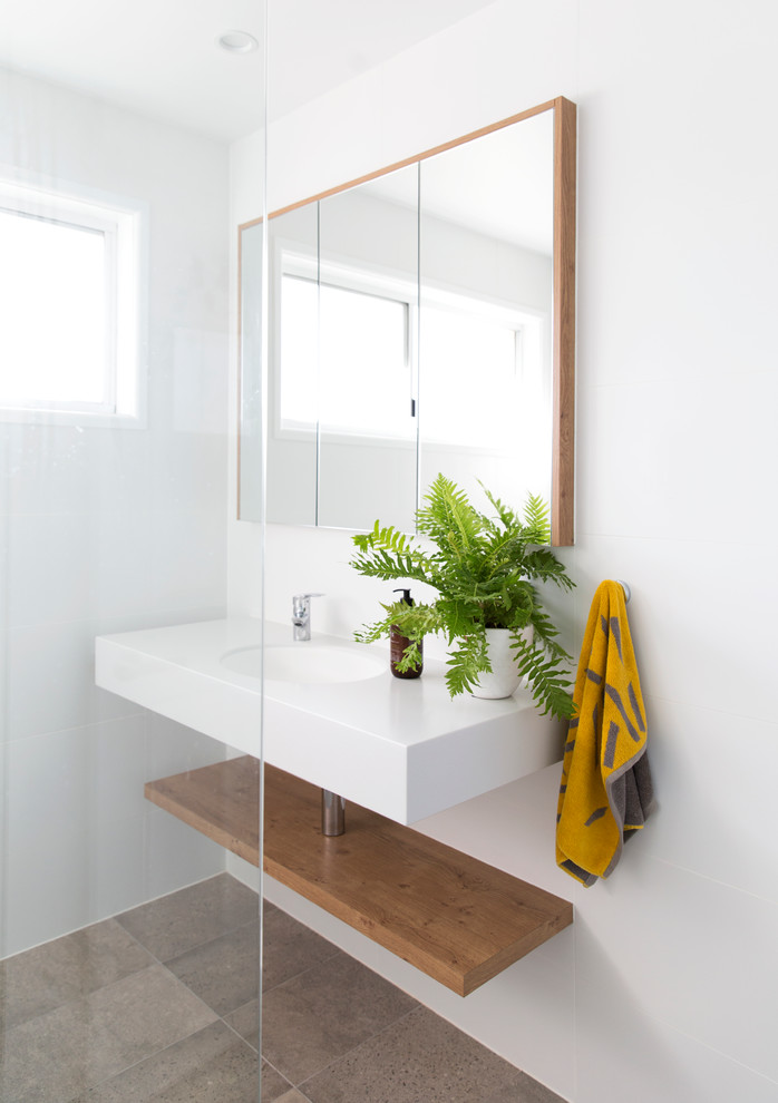 Design ideas for a small scandinavian bathroom in Gold Coast - Tweed with flat-panel cabinets, white cabinets, a corner tub, a corner shower, a one-piece toilet, white tile, ceramic tile, an integrated sink and engineered quartz benchtops.