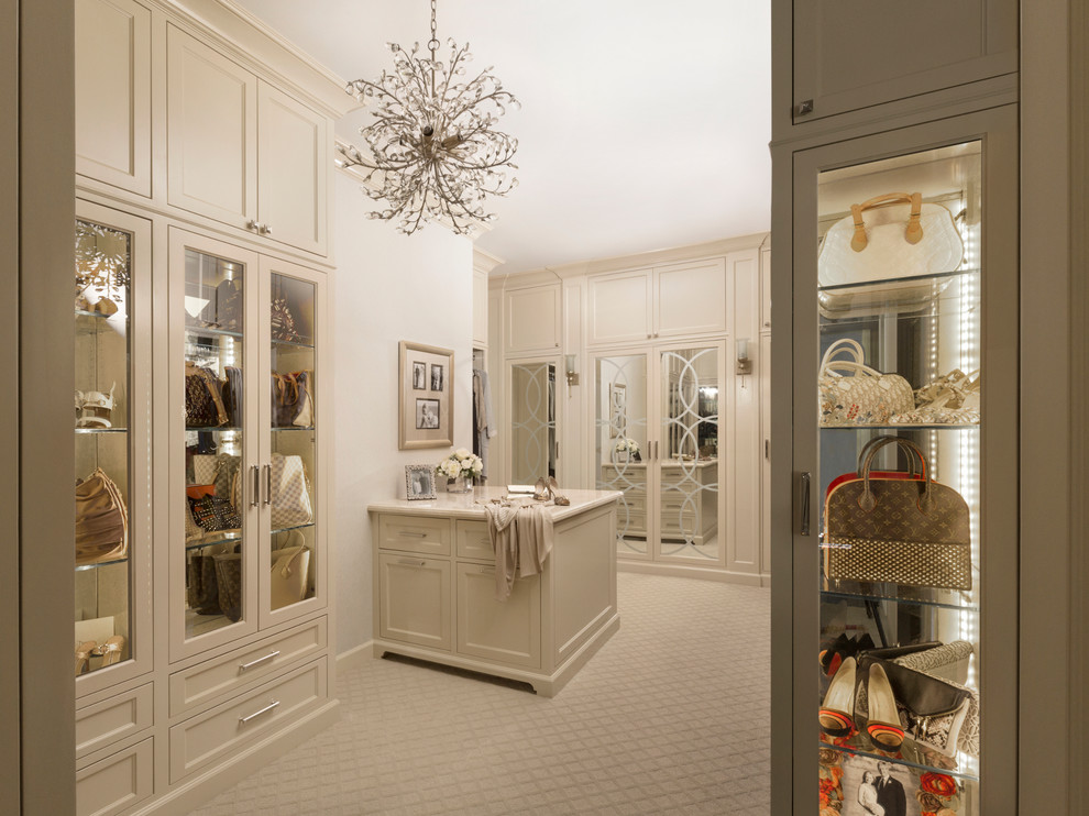 This is an example of a large transitional women's walk-in wardrobe in Other with recessed-panel cabinets, light wood cabinets, carpet and beige floor.