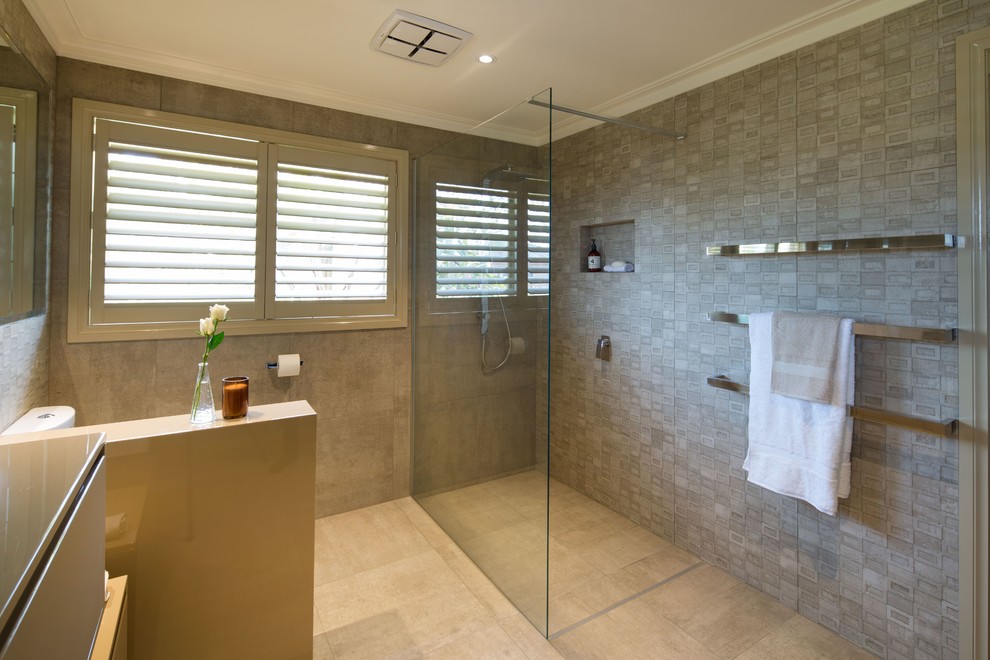 Design ideas for a mid-sized contemporary master bathroom in Melbourne with raised-panel cabinets, beige cabinets, a curbless shower, a one-piece toilet, beige tile, porcelain tile, beige walls, porcelain floors, a drop-in sink and engineered quartz benchtops.