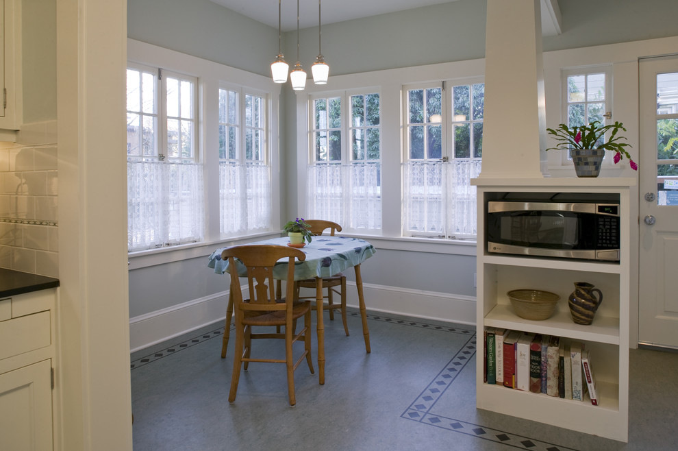Inspiration for a mid-sized arts and crafts galley separate kitchen in Portland with a farmhouse sink, shaker cabinets, white cabinets, granite benchtops, white splashback, subway tile splashback, stainless steel appliances, linoleum floors and no island.