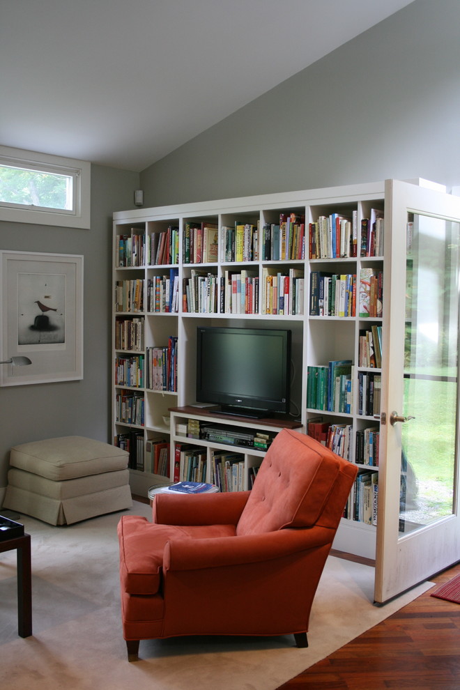 Inspiration for a contemporary family room in Burlington with a library, grey walls, medium hardwood floors and a freestanding tv.