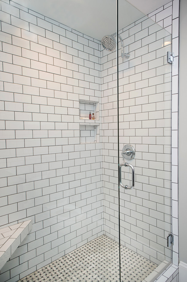 This is an example of a mid-sized industrial 3/4 bathroom in Charlotte with raised-panel cabinets, black cabinets, a corner shower, white tile, subway tile, white walls, marble floors, a vessel sink, white floor, a hinged shower door and black benchtops.
