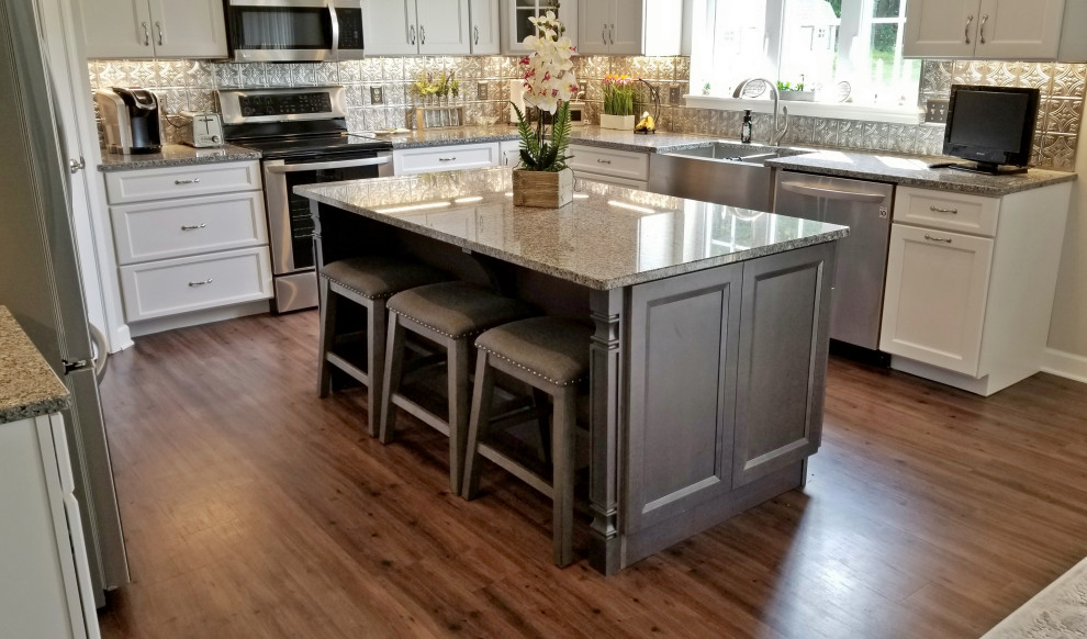 Inspiration for a mid-sized transitional u-shaped vinyl floor and multicolored floor eat-in kitchen remodel with a farmhouse sink, recessed-panel cabinets, white cabinets, granite countertops, metallic backsplash, metal backsplash, stainless steel appliances, an island and gray countertops