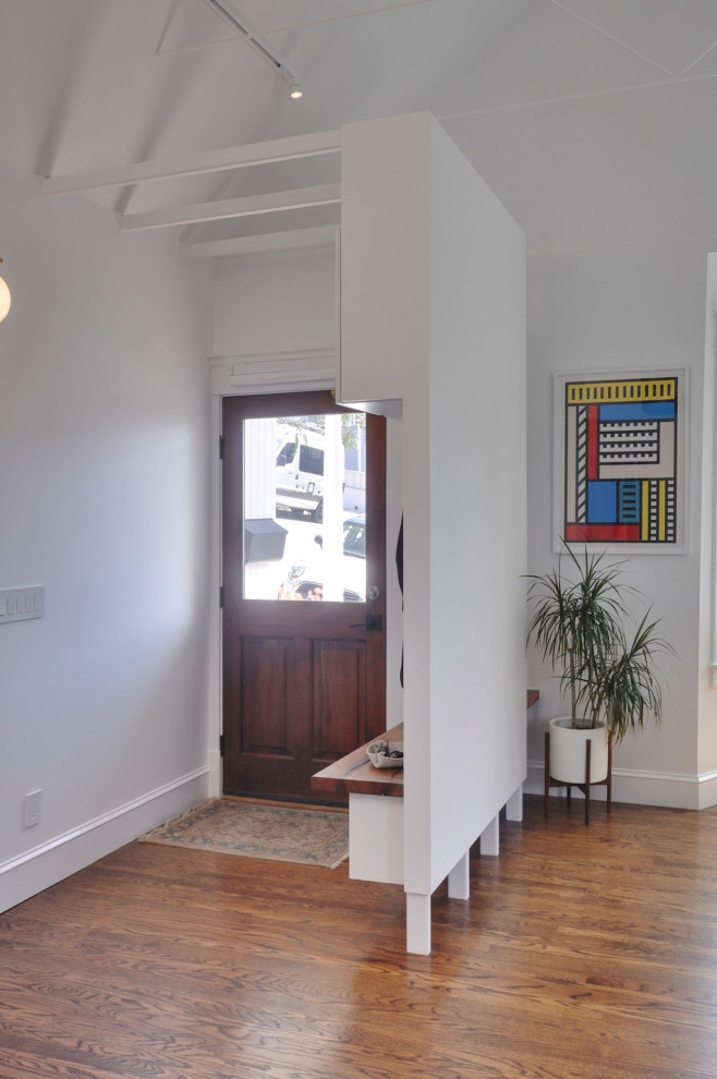 Свежая идея для дизайна: маленький вестибюль в современном стиле с белыми стенами, темным паркетным полом, входной дверью из темного дерева, коричневым полом и сводчатым потолком для на участке и в саду - отличное фото интерьера