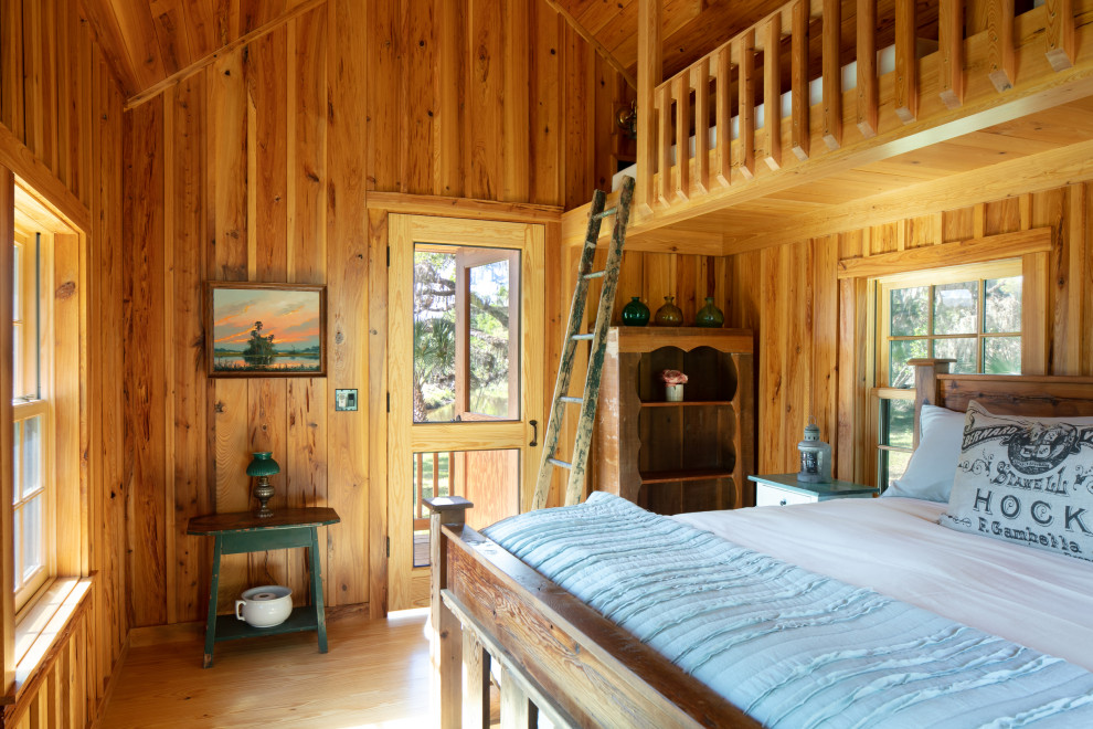 Cette image montre une grande chambre parentale rustique en bois avec un mur marron, un sol en bois brun, aucune cheminée, un sol marron et un plafond en bois.