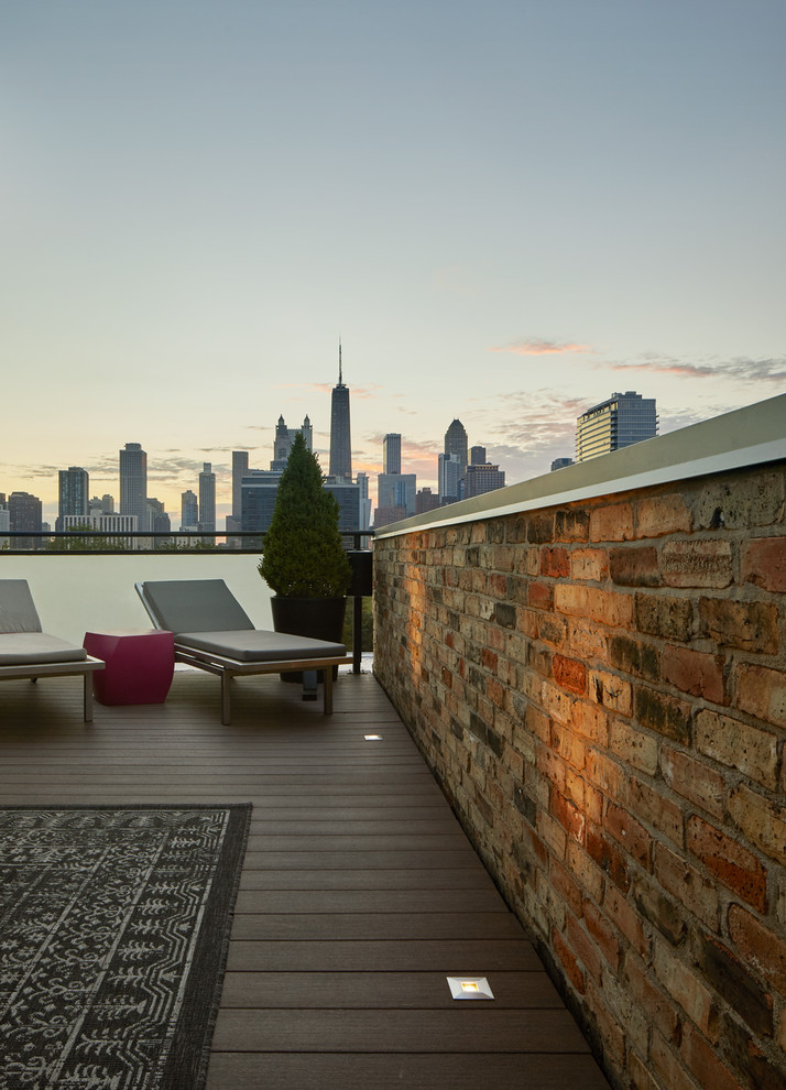 Mid-sized modern rooftop deck in Chicago with a fire feature and an awning.