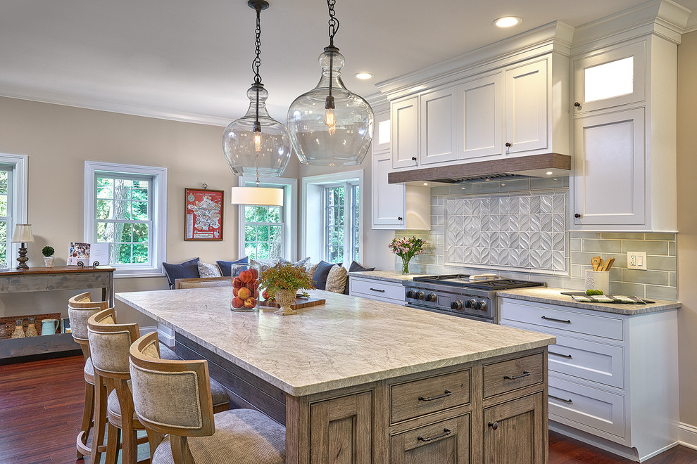 This is an example of a large transitional galley eat-in kitchen in Chicago with an undermount sink, beaded inset cabinets, white cabinets, quartzite benchtops, blue splashback, ceramic splashback, stainless steel appliances, medium hardwood floors, with island, red floor and grey benchtop.