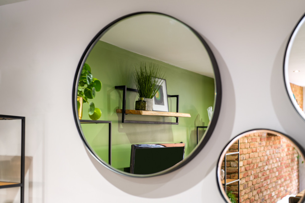 Стильный дизайн: гостиная комната среднего размера в стиле лофт с зелеными стенами, полом из керамогранита, телевизором на стене, серым полом и акцентной стеной без камина - последний тренд