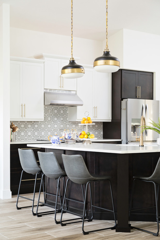 Transitional l-shaped beige floor kitchen photo with shaker cabinets, black cabinets, stainless steel appliances, an island and white countertops