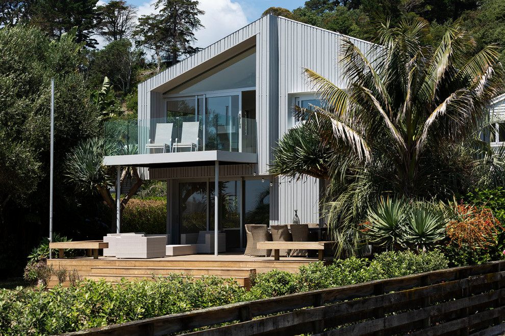 На фото: большой, двухэтажный, серый частный загородный дом в стиле модернизм с комбинированной облицовкой, двускатной крышей, металлической крышей, серой крышей и отделкой доской с нащельником