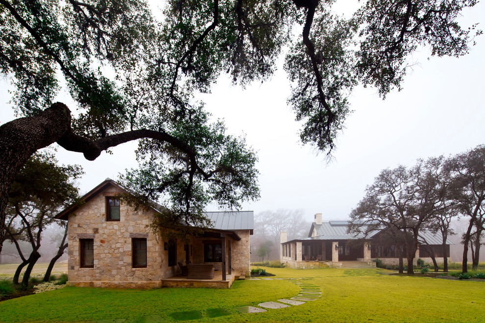 Farmhouse two-story stone gable roof idea in Austin