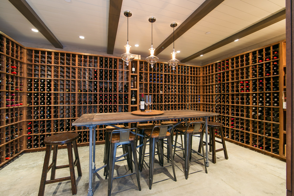 This is an example of a large country wine cellar in Orange County with storage racks and beige floor.