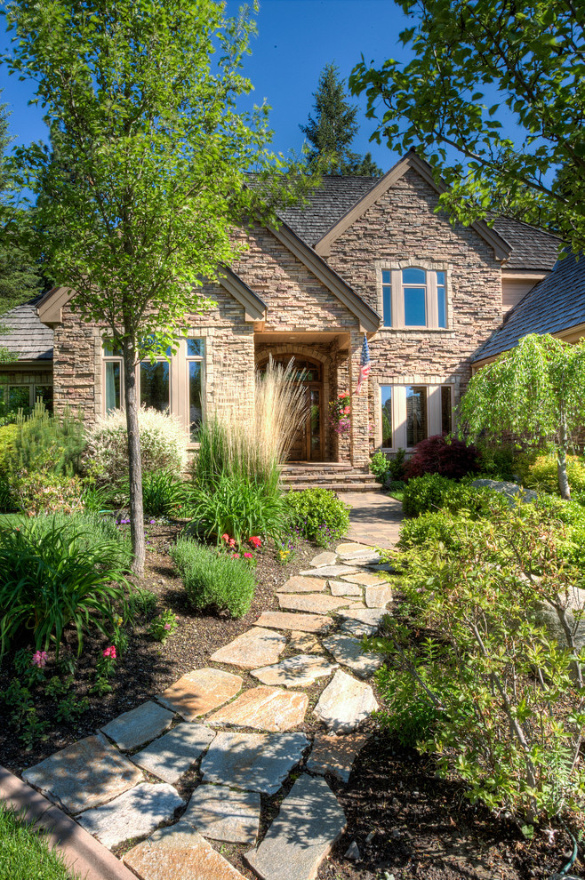 This is an example of a traditional front yard garden in Seattle with natural stone pavers.