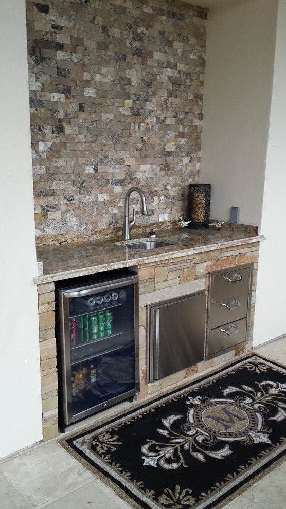 This is an example of a large arts and crafts single-wall wet bar in Austin with an undermount sink, granite benchtops, multi-coloured splashback and stone tile splashback.